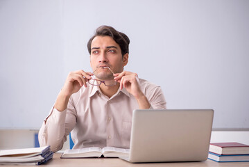 Young male teacher student sitting in the classroom