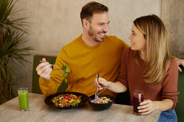Couple eating salad in the salad bar and drinking organic juice