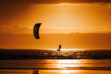 kitesurfing with golden silhouette, ai - obrazy, fototapety, plakaty