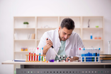 Young male chemist sitting at the lab