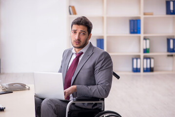 Young employee in wheel-chair working in the office