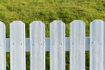 White picket fence with green grass.