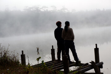 Two people on a misty waterfront