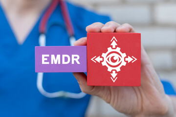 Young female doctor holding colorful blocks with banner: EMDR. Medical concept of EMDR Eye Movement...