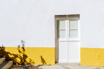 Beautiful typical facade with yellow and white walls in Tavira, Algarve, Southern Portugal.