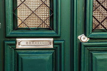 Detail of a beautiful typical and green door with mailbox in Tavira, Algarve, Southern Portugal.