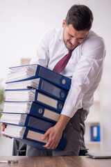 Young male employee and too much work in the office