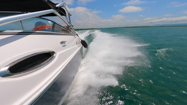High speed motorboat moving fast on the surface of the sea. Splash from dissected waves. Side view of the vessel