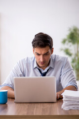 Fototapeta premium Young male employee working in the office