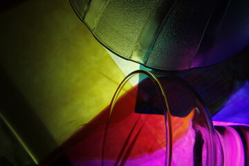 Copa de cristal acostada con círculo de un cuenco de cristal texturizado, con luz multicolor forma...
