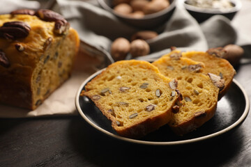 Cut pumpkin bread with pecan nuts on wooden table, closeup