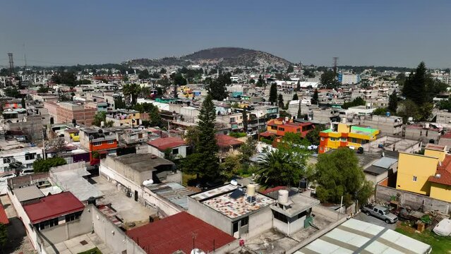 Aerial view low over the Iztapalapa favela neighborhood, in sunny Mexico city