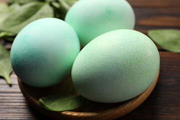Naturally painted Easter eggs on wooden table, closeup. Spinach used for coloring
