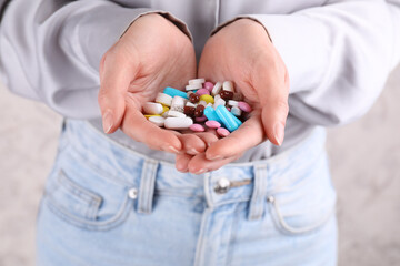 Woman holding pile of antidepressants, closeup view