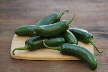 Fresh green jalapeno peppers on wooden table, closeup