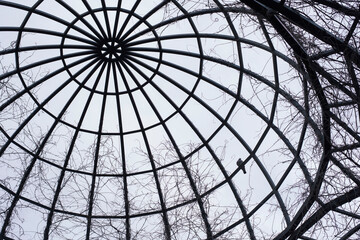 C&uacute;pula de acero con una paloma posada en la estructura con el cielo de fondo