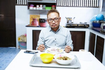 middle aged man eating Alone at the dining table