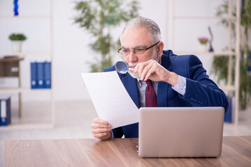 Old male employee working in the office