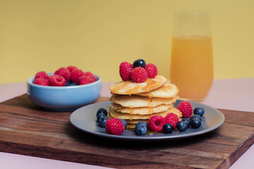 Delicious pancakes with berries, honey or maple syrup. Homemade pancake stack and sweet syrup
