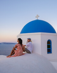 Couple on vacation in Santorini Greece, men, and women on the streets of the Greek village of Oia Santorini - obrazy, fototapety, plakaty