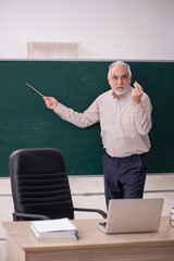 Old male teacher in the classroom