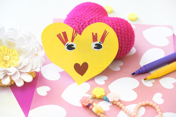 Child making funny crafts  from paper and clay, plasticine. Hearts  as gift for Mothers day, Fathers day, Birthday or Valentines day . Arts  crafts concept.
