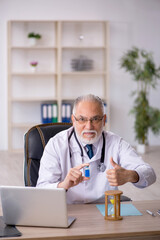 Old male doctor in time management concept