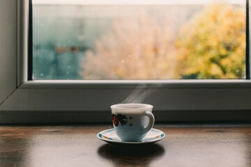 Hot cup of tea in bright light morning by the windows.