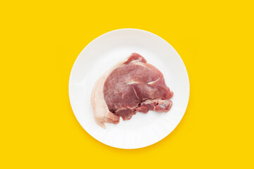 Pork meat on yellow background.