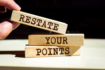 Wooden blocks with words 'RESTATE YOUR POINTS'.