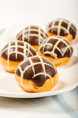 Six pack of gluten-free profiteroles covered in milk and white chocolate and filled with fresh cream