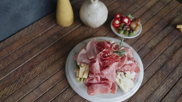 Italian deli antipasto plate with olives, crackers, cheese, and meat. Italian appetizer board with salami, prosciutto, meats, and cheeses.