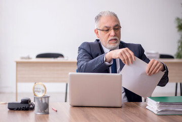 Old male employee working in the office