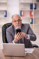 Old male employee working in the office