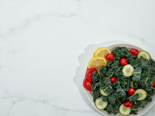 Dinosaur Kale Salad in bowl on white marble background