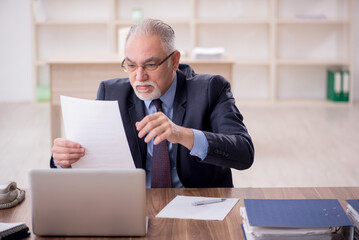 Old male employee working in the office