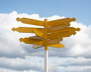 Sign of indecision concept, blank multiple direction signpost, multiple options, yellow empty directional signposts against blue sky with clouds background 