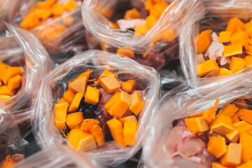 Process of preparing bowls with natural raw pet dog food at home, preparation of healthy raw barf for cats dogs, with duck, turkey, offals, meat, vegetables, assorted fresh portions in containers bags