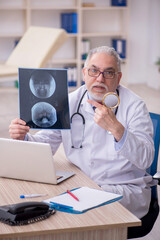 Old male doctor radiologist working in the clinic