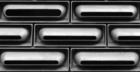 Vents.  Part of a wall of a futuristic building with horizontal vent-like openings in Tai Kwun, Hong Kong.  In black and white.