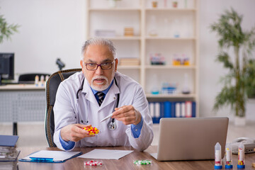 Old male doctor pharmacist in drugs synthesis concept