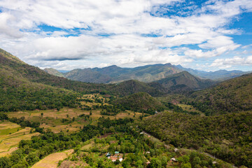 Fototapeta na wymiar Aerial drone of Rice fields and terraces in a valley among the mountains. Agricultural landscape in Sri Lanka.