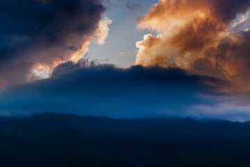 Spectacular sun set with colourful clouds in the sky beyond mountain peaks. Shot at Okhrey, Sikkim, India.