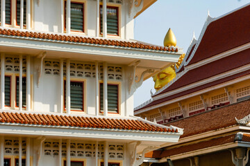 Fototapeta na wymiar Huge Buddha image that appears between the buildings. big buddha Buddha image on the roof of buildings. Buddha temple in Thailand 