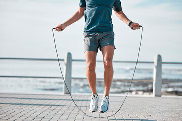 Jump rope, fitness and man by a sea promenade with training, sports and exercise equipment. Health,...
