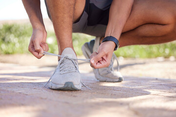 Fitness, running and man tie shoes ready to start exercise, marathon training and endurance workout. Sports, nature trail and feet of male runner tying shoelace for wellness, health and performance