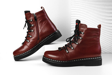 Women's boots on the platform on a white background. Burgundy shoes. Trend shoes. Stylish look. Fashion shoes still life. stylish photo in the studio