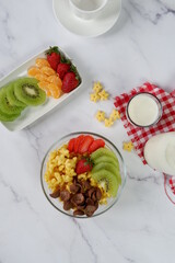 Healthy breakfast with cereal, strawberry, orange and milk
