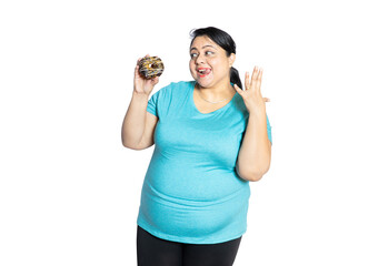 Happy plus size indian woman holding chocolate donut tempting to eat isolated over white background,studio portrait. Copy space.