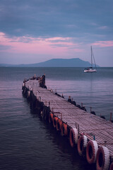 Old wooden fishing pier goes into the sea on sunset. Resort city Novyi Svet, Crimea